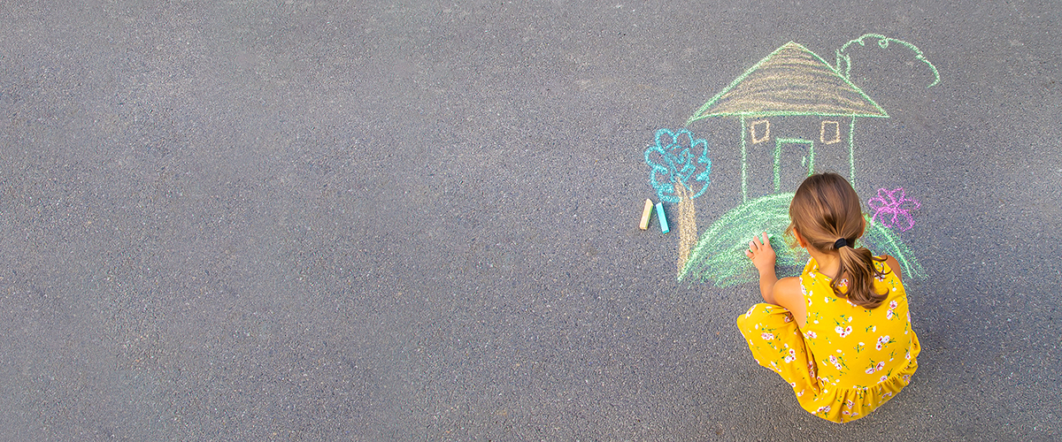 The Child Draws A House On The Asphalt. Selective Focus.